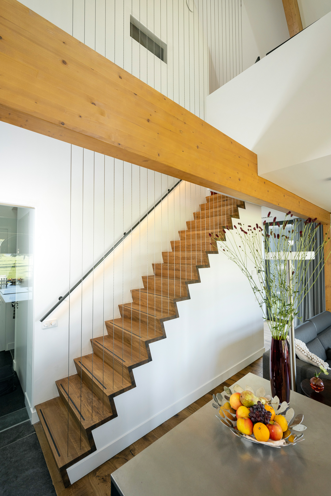 Moderne houten trapafwerking in schuurwoning villa Schalkwijk Interieur van schuurwoning villa met houten trap en zichtbare balk in Schalkwijk